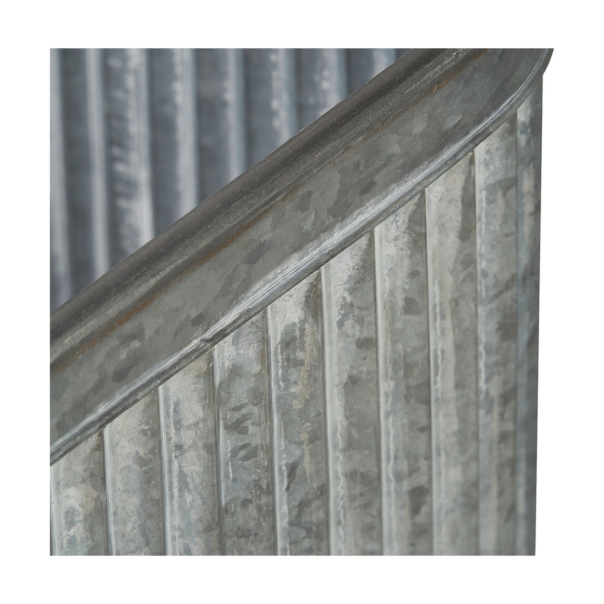 Close-up of a galvanised zinc planter's ridged, corrugated side panel and rolled rim, showing the textured metal finish and visible weld seam.