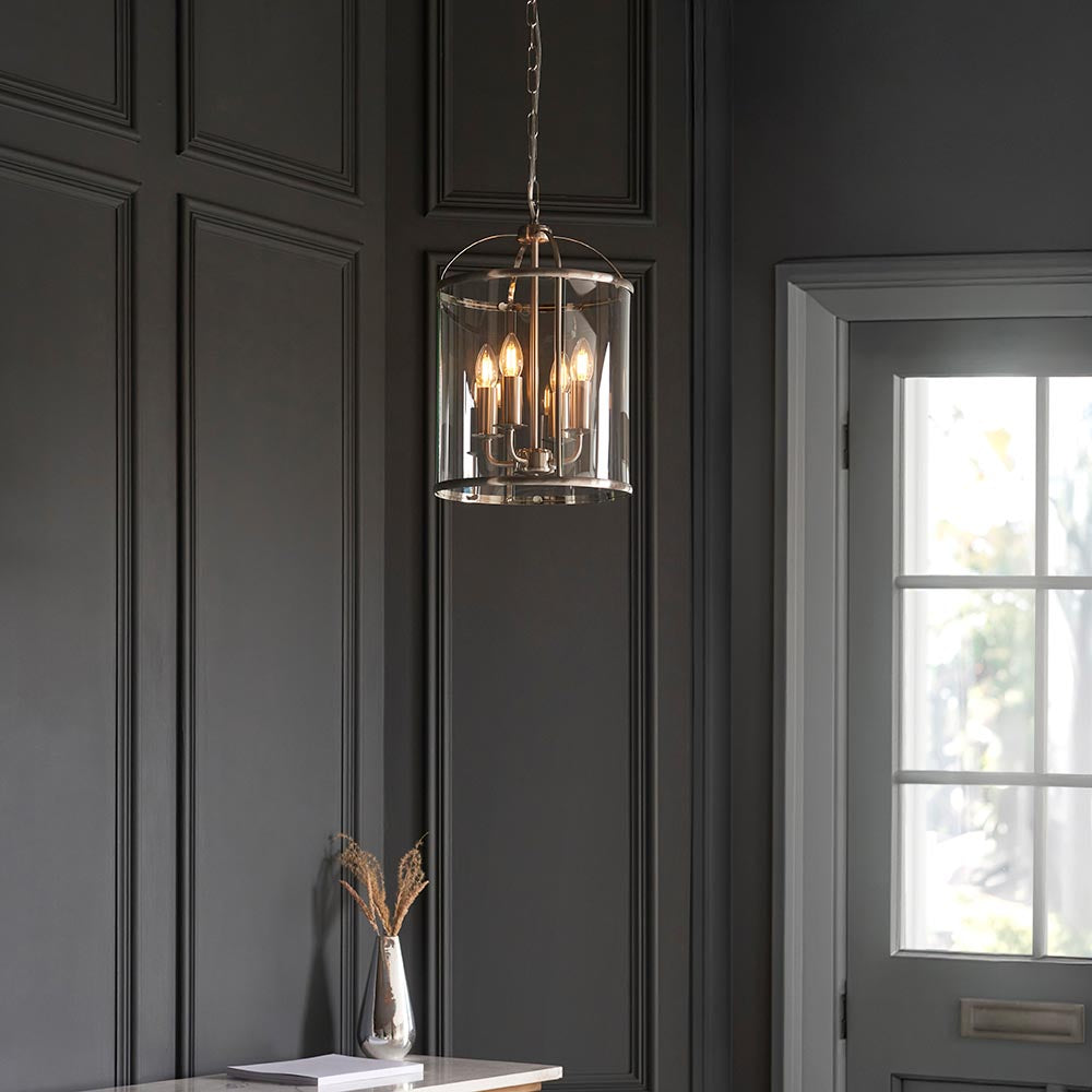 Endon Caldbury 4 light pendant in nickel with clear glass panels and E14 candle lamps, hung from a chain in a dark panelled hallway near a window.