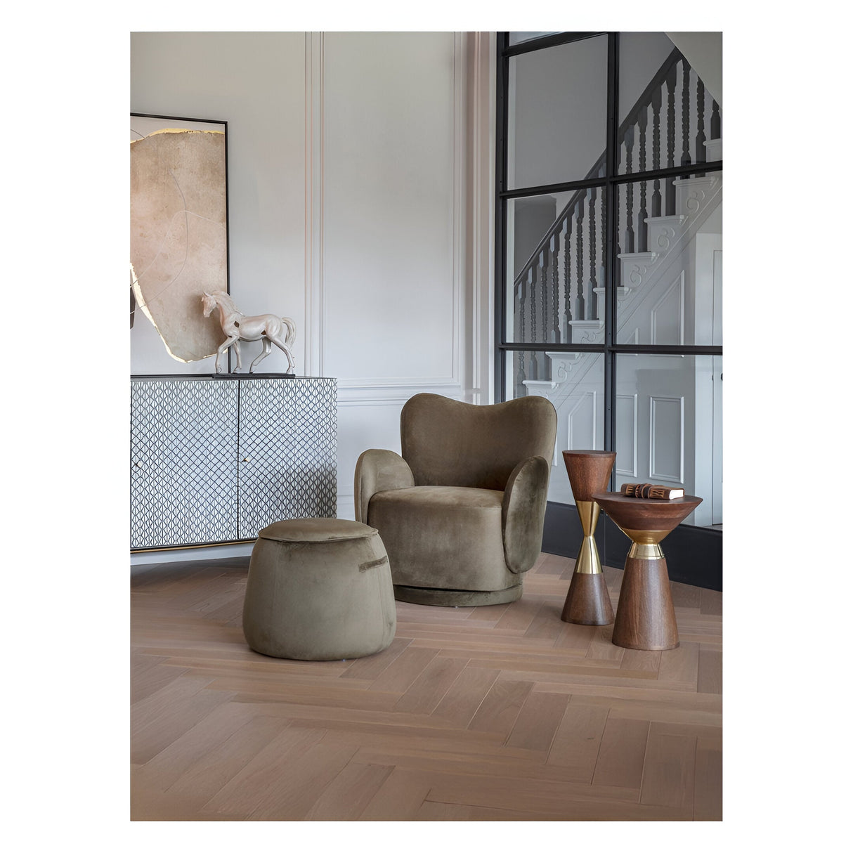 Libra Interiors Amalfi side tables in dark mango wood with brass-effect bands, paired with a velvet armchair and ottoman in a panelled period interior.