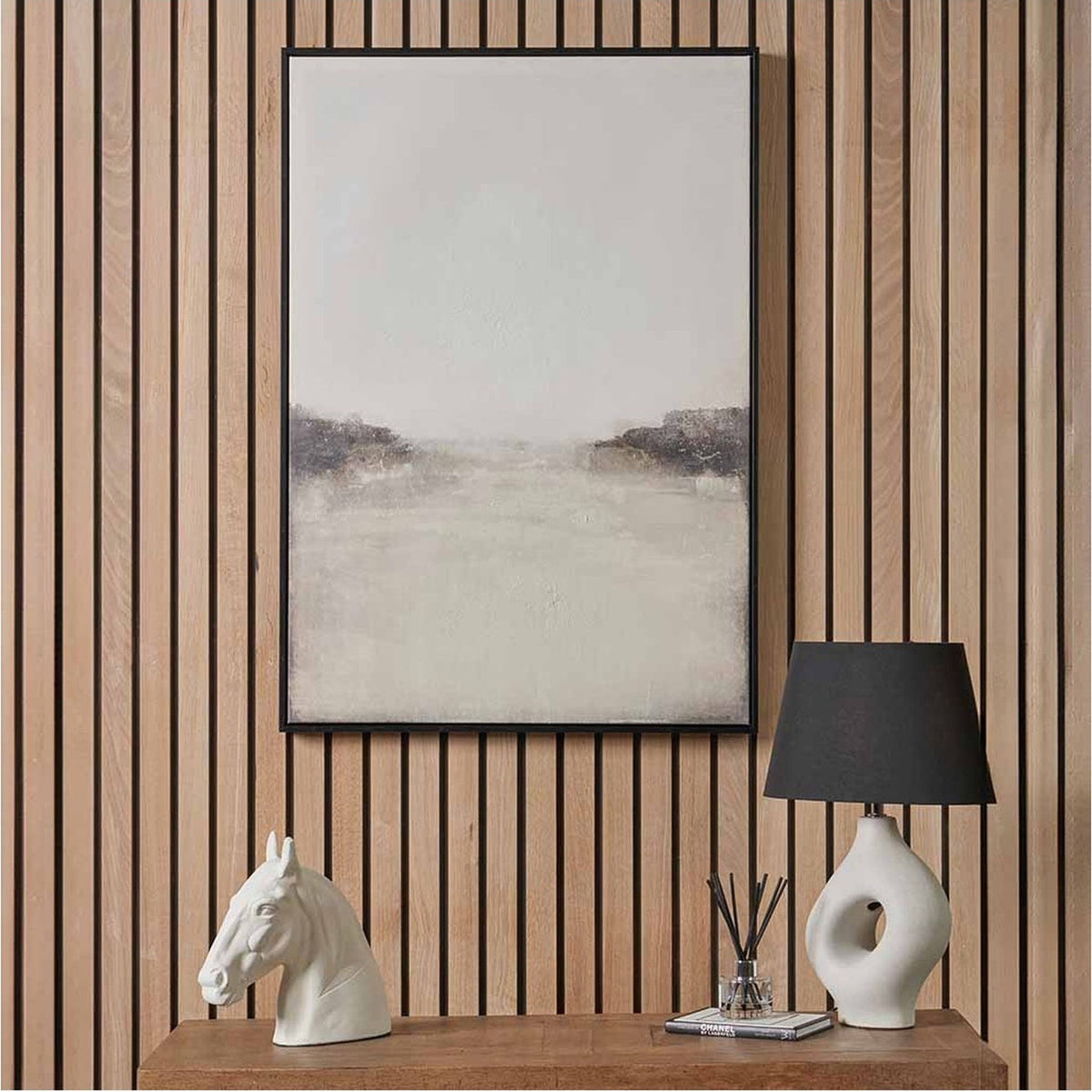 Grey & White Abstract Canvas with Black Frame (70 x 100cm) hung on a wood-slatted wall above a console table with a white horse head sculpture and lamp.
