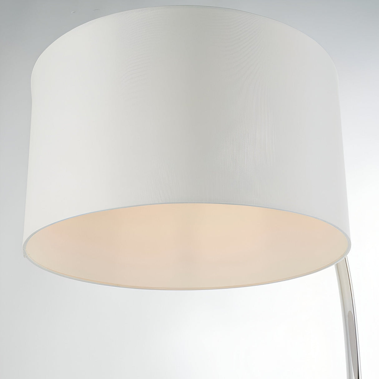 Close-up of the Brockfield Floor Lamp's large drum shade in white faux silk with a polished nickel arm visible, on a plain light background.