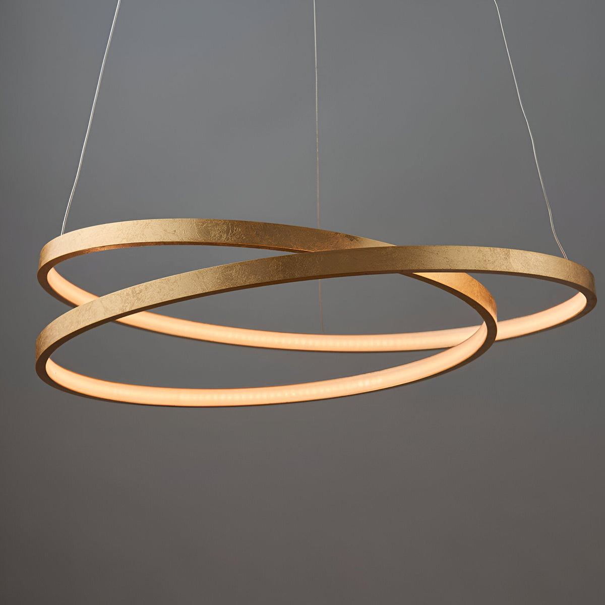 Endon Cliffley ring pendant in gold leaf finish, formed as intertwined circular hoops with integrated LED, suspended against a grey background.
