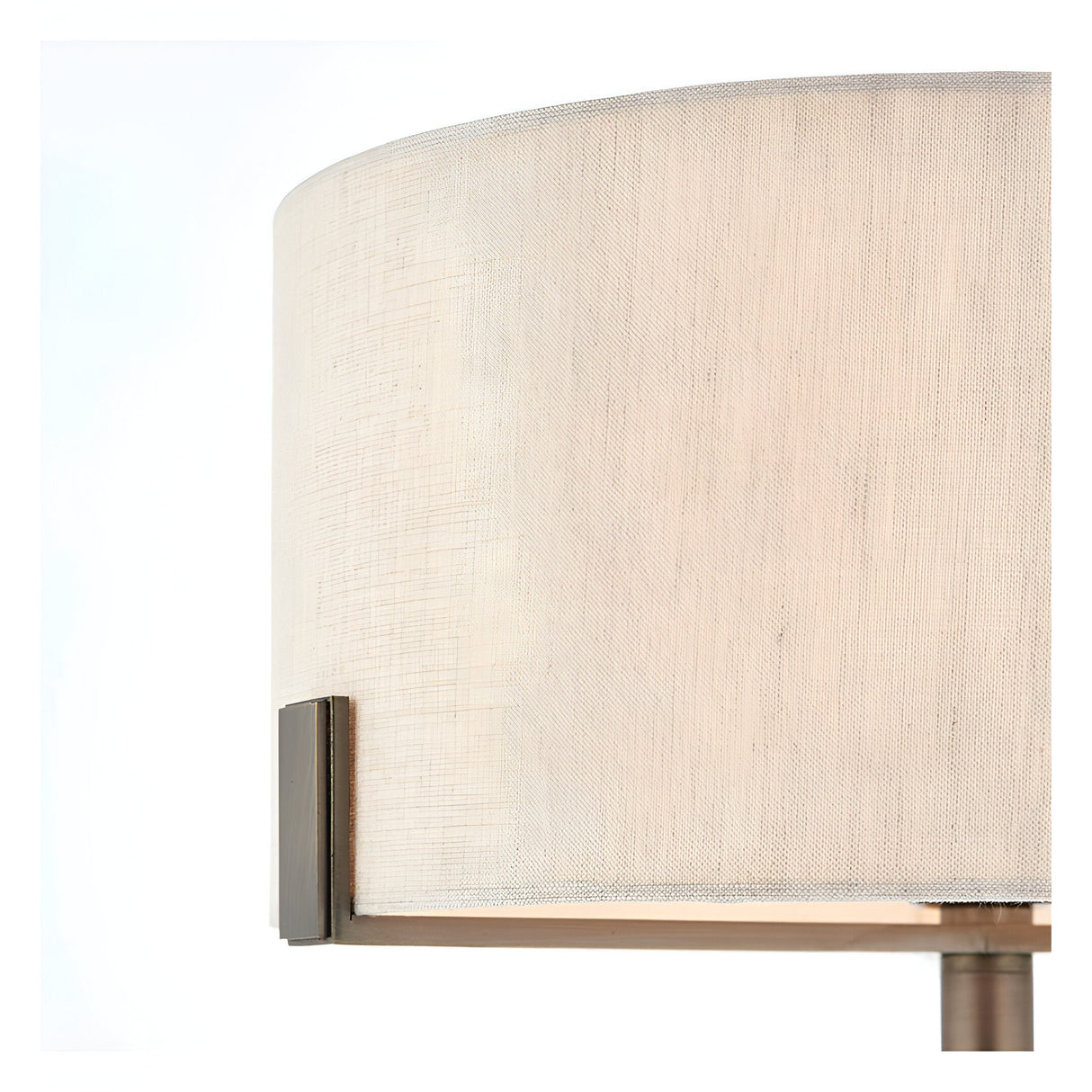 Close-up of the Brendon Table Lamp's natural linen drum shade with bronze bracket detail, set against a plain white background.