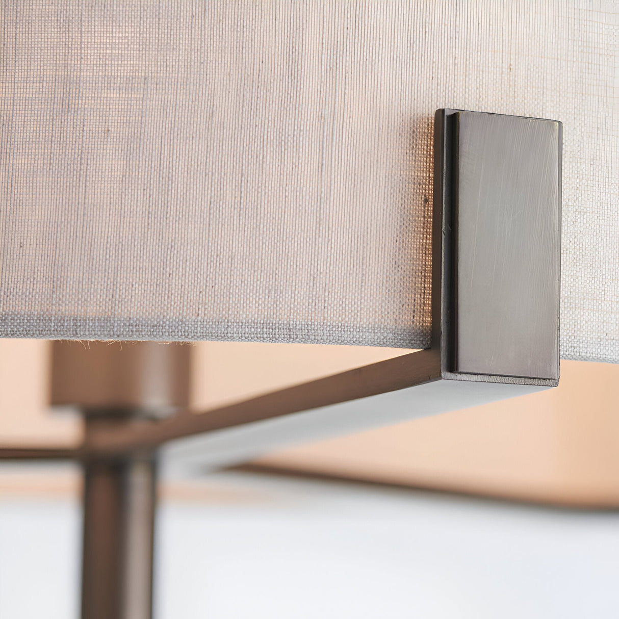 Close-up of the Endon Brendon floor lamp showing the slim bronze metalwork bracket supporting the natural linen fabric shade.
