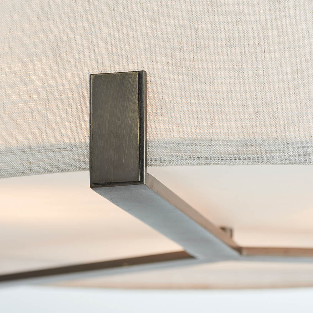 Close-up of the Brendon 3 Light Pendant's bronze metal bracket and arm attaching to the natural fabric shade, showing brushed finish detail.