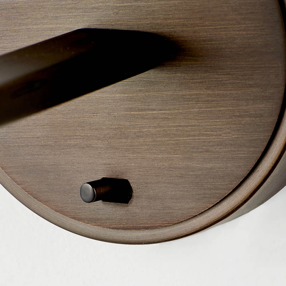 Close-up of the Endon Bexley wall light in bronze, showing the brushed dark antique arm base and small on/off toggle switch on the round mount.