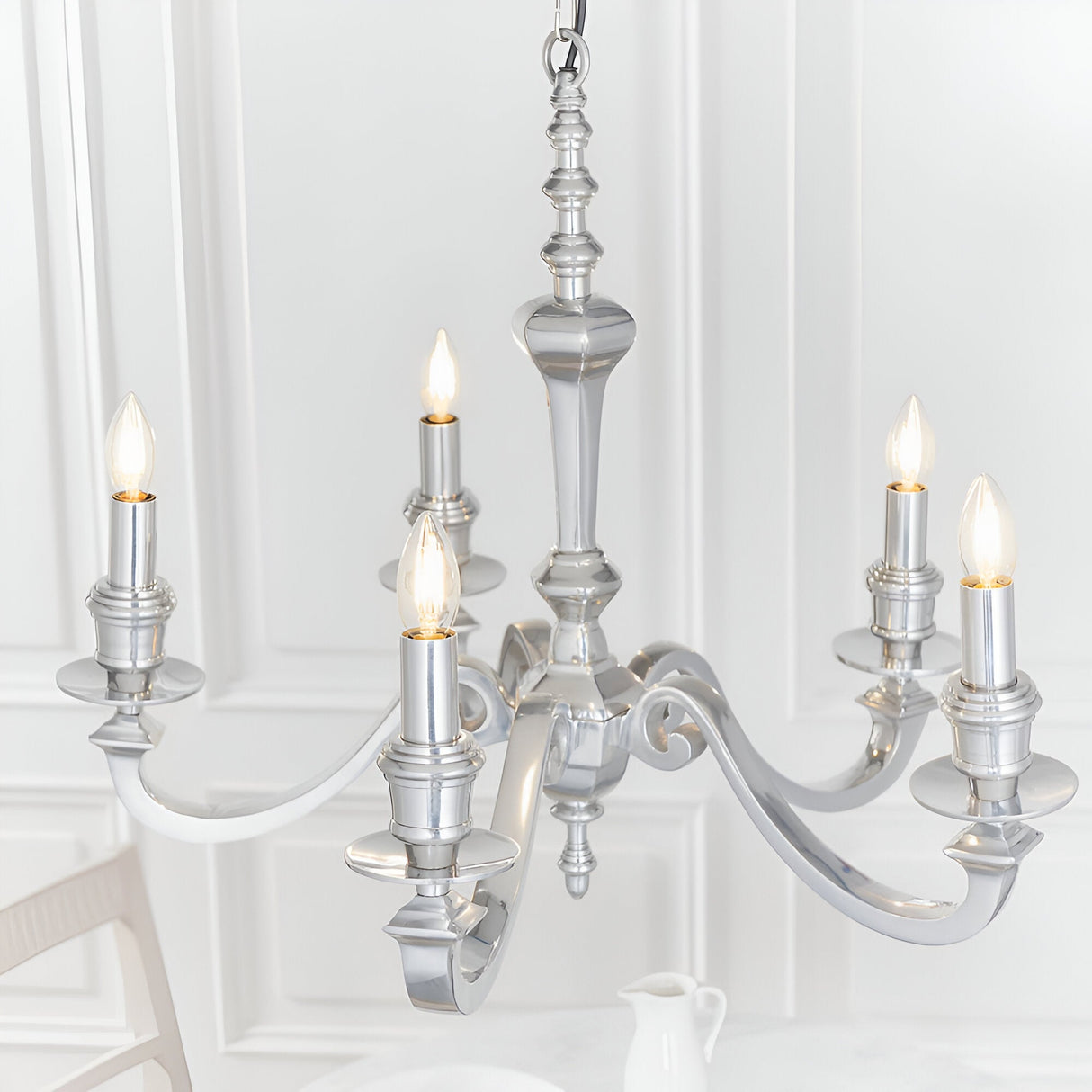 Endon Brambourne 5 light pendant in polished aluminium with curved arms and upward candle-style lamps, shown against a white panelled dining room wall.