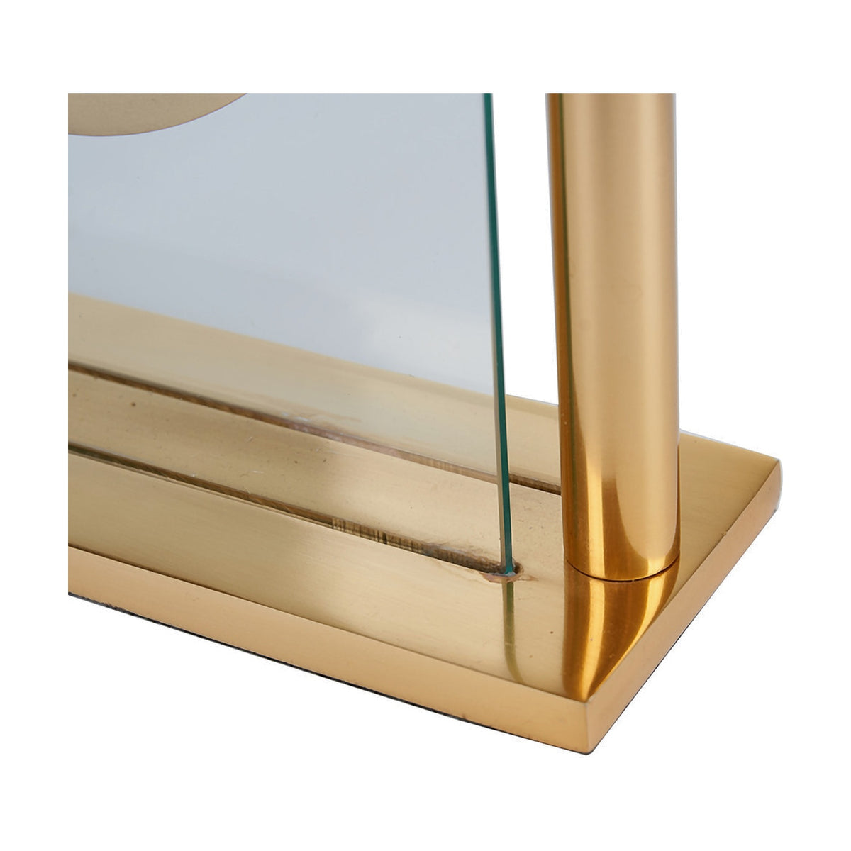 Close-up of the Gold Brass & Glass Floating Clock Face Table Clock's base, showing a gold metal plinth, cylindrical brass support, and clear glass panel against a white background.
