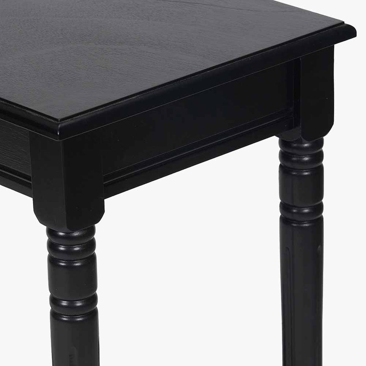 Close-up of the Heritage Black Pine Console Table, 80cm, showing a black wood tabletop with overhang above turned legs and a frame apron.