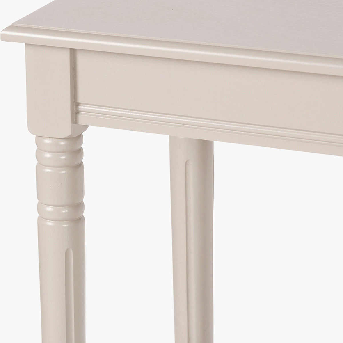 Close-up of the Heritage Putty Pine Console Table in cream painted wood, showing turned and fluted legs, a beaded apron edge, and tabletop overhang on a white background.
