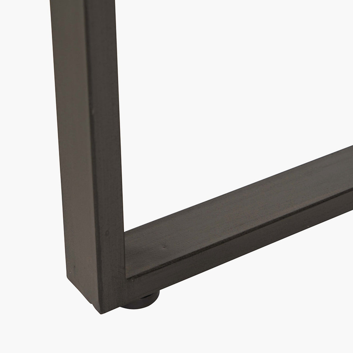 Close-up of the Marca Bar Dining Table's black iron frame corner and leg, showing a wood tabletop edge on a plain white background.
