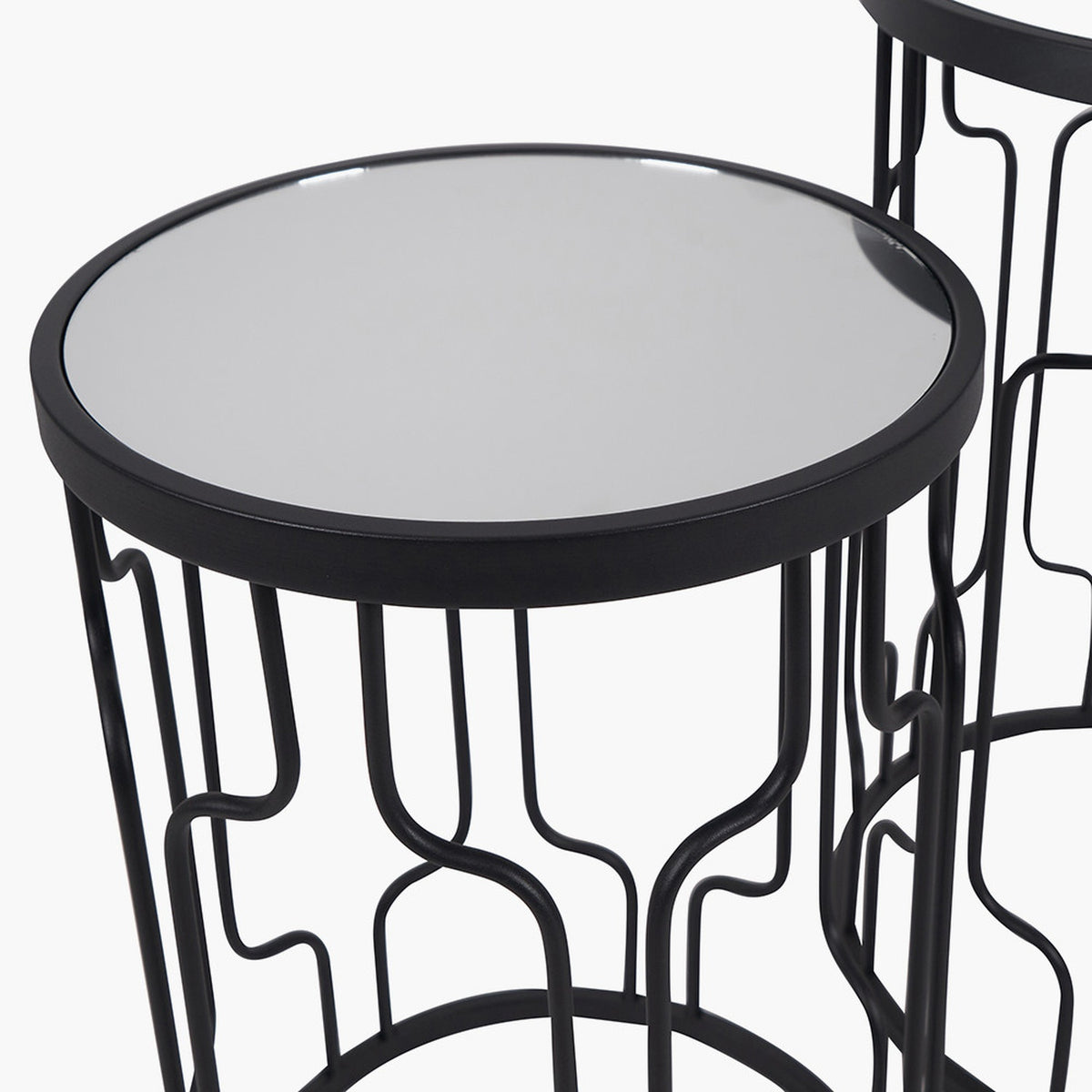 Caprisse round side table in graphite iron with mirrored glass top, showing curved wave-patterned metal legs, on a plain white background.