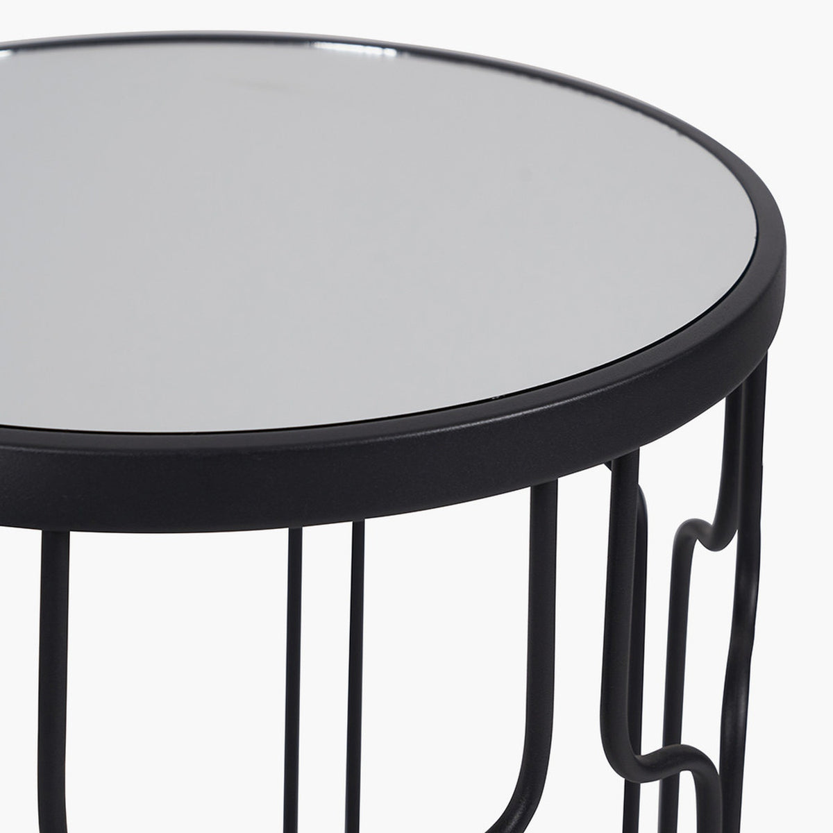 Close-up of the Caprisse side table's round mirrored glass top and graphite iron rim, showing wire and curved loop legs beneath, on a plain white background.