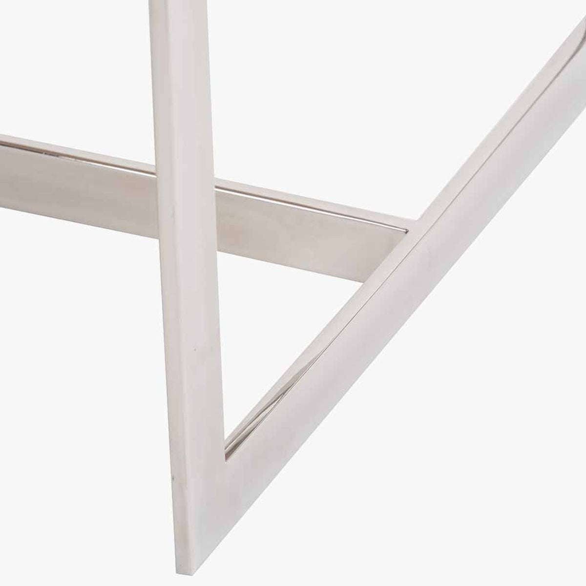 Close-up of the Evelyn coffee table's angled mango wood and silver metal frame, showing the crossed leg joinery on a plain white background.