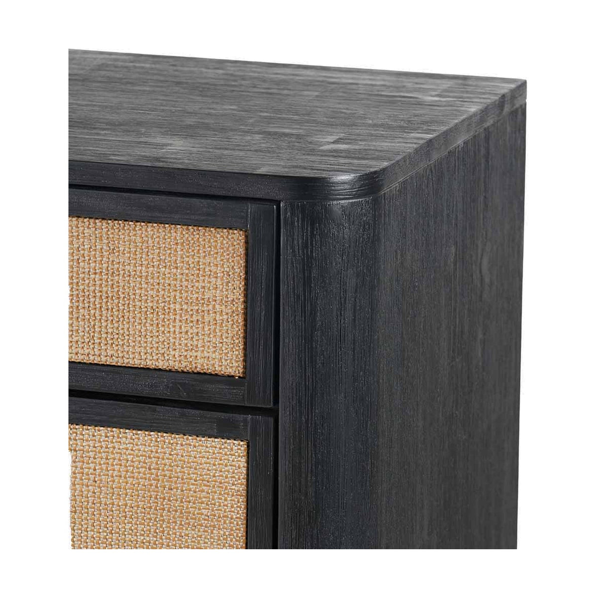 Close-up of the Fiji Black Acacia & Rattan 4 Drawer Unit's corner, showing black wood grain finish, rounded edge, and woven rattan drawer fronts on a white background.