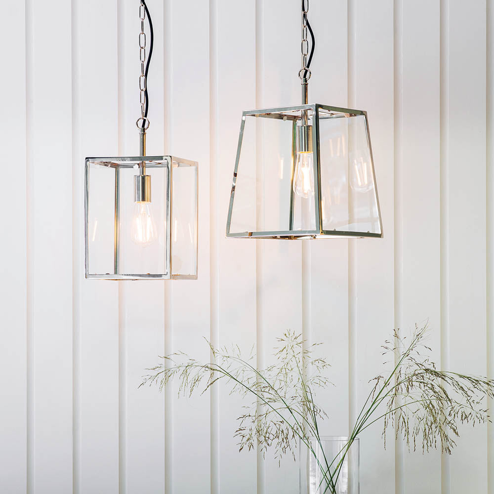 Brenton Lantern Pendant in nickel, box-frame design with clear glass panels and exposed filament bulb, shown in pairs against a white panelled wall.