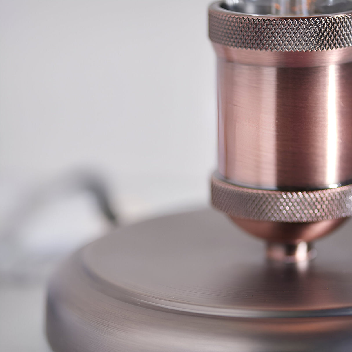 Close-up of Endon Brackley table lamp showing copper cylindrical body, knurled pewter lamp holder detail, and brushed metal base.