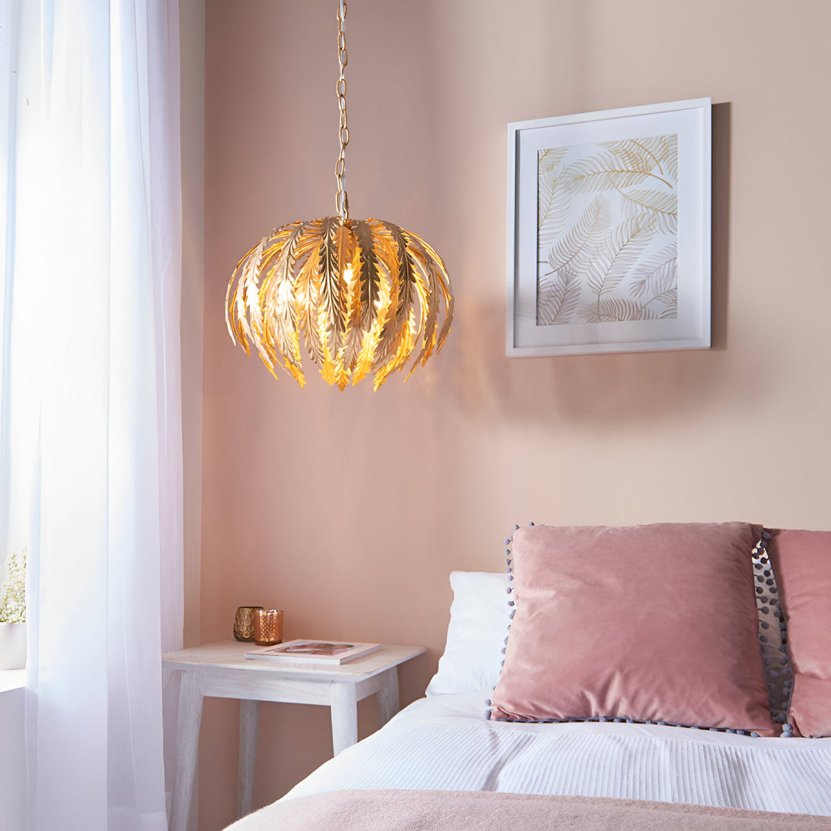 Endon Colette 3 light pendant in gold with layered leaf shade on a chain, hung beside a framed botanical print in a soft pink bedroom.