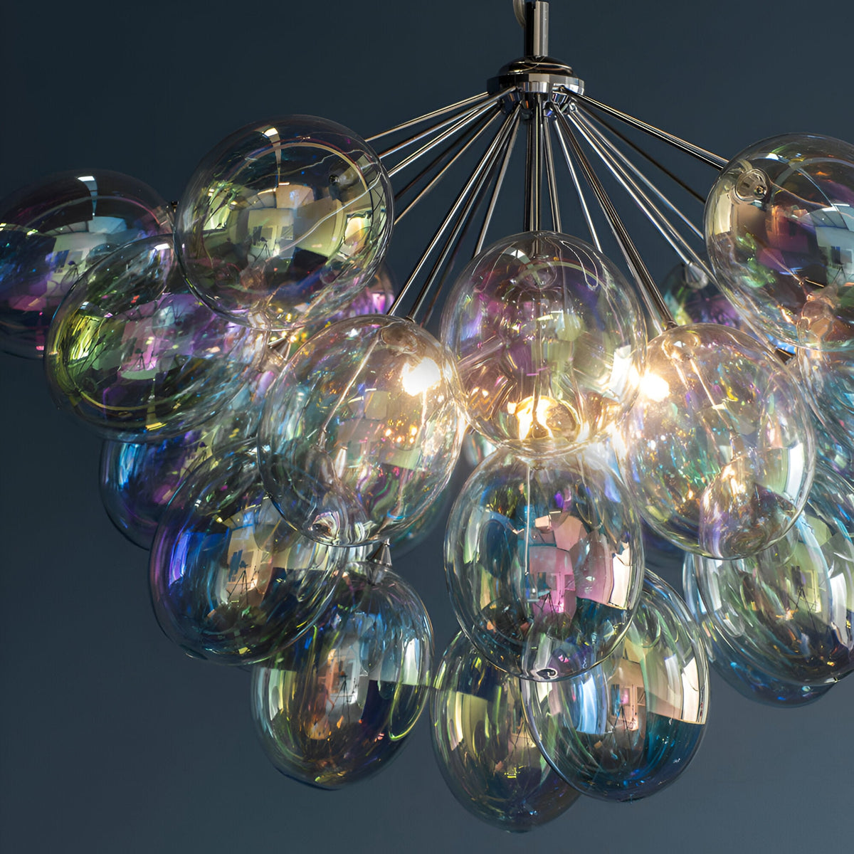 Endon Brenworth 6 light pendant in chrome with a cluster of iridescent glass globe shades reflecting shifting colours against a dark background.