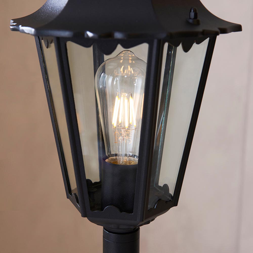 Endon Ashshaw Bollard Light in matt black die cast aluminium with clear glass lantern panels and a lit E27 filament bulb inside.