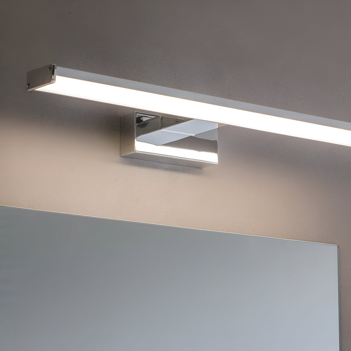 Endon Aldshaw LED bathroom wall light in chrome with a slim frosted diffuser bar, mounted above a mirror on a neutral wall.