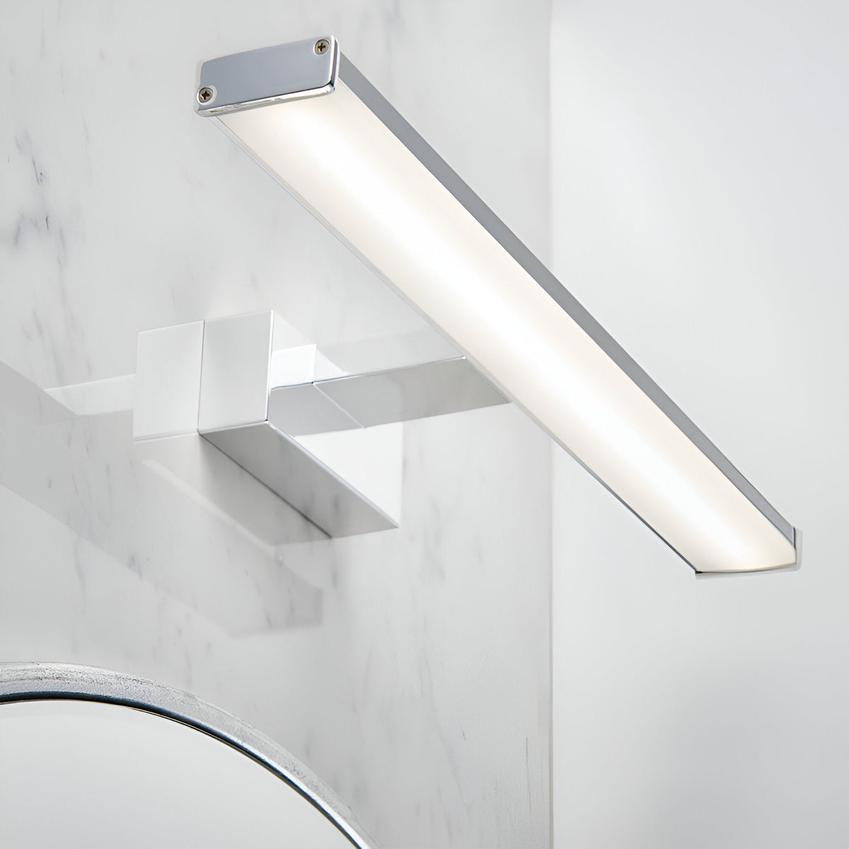 Endon Aldshaw LED bathroom wall light in chrome with a slim frosted diffuser bar, mounted on a marble wall above a chrome tap and mirror.