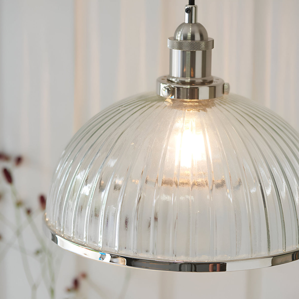 Wentworth Pendant Light in nickel, close-up of ribbed clear glass dome shade with metal rim and knurled lamp holder, lit bulb visible, plain neutral background.