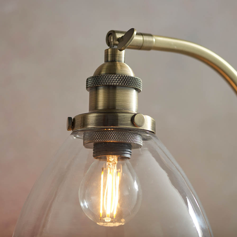 Wentworth Table Lamp in brass, close-up of the knurled lamp holder, adjustable knuckle joint, and clear glass shade with visible E14 bulb.