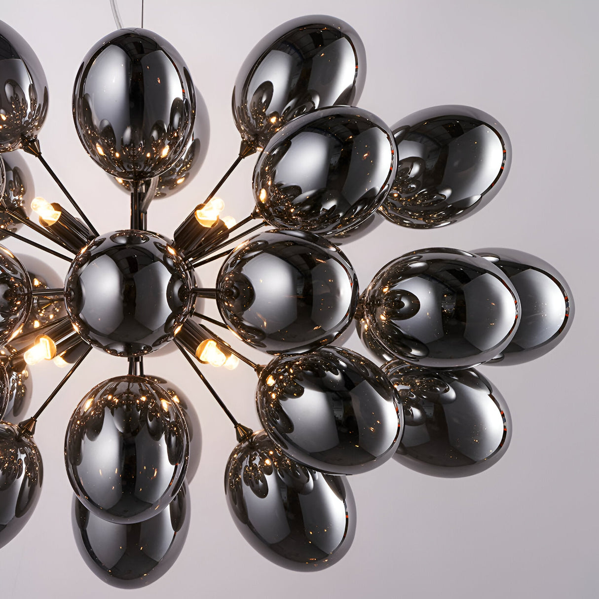 Endon Brenworth 8 light pendant in black chrome with cluster of electro-plated dark chrome glass shades and warm G9 lamps, shown against a pale background.