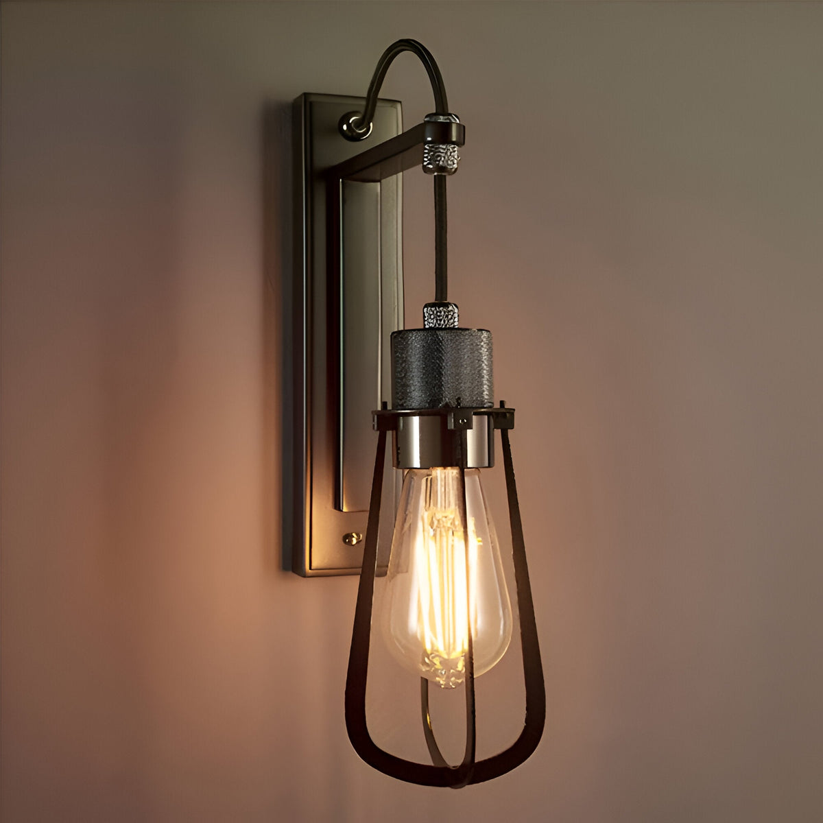 Endon Camden industrial wall light in chrome and black with a caged teardrop shade, exposed Edison bulb, and rectangular wall bracket mounted on a pale wall.