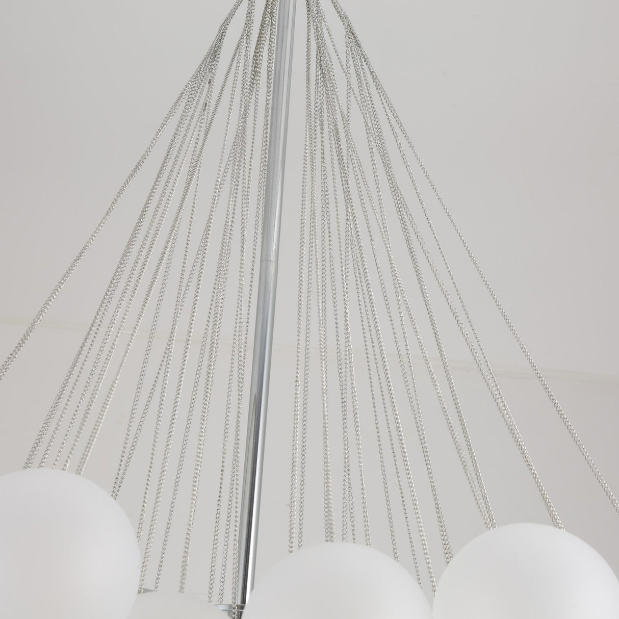 Close-up of the Orb 37 Light Cluster Suspension in silver, featuring multiple chains from a central rod and frosted glass globes, suspended elegantly against a plain white ceiling.