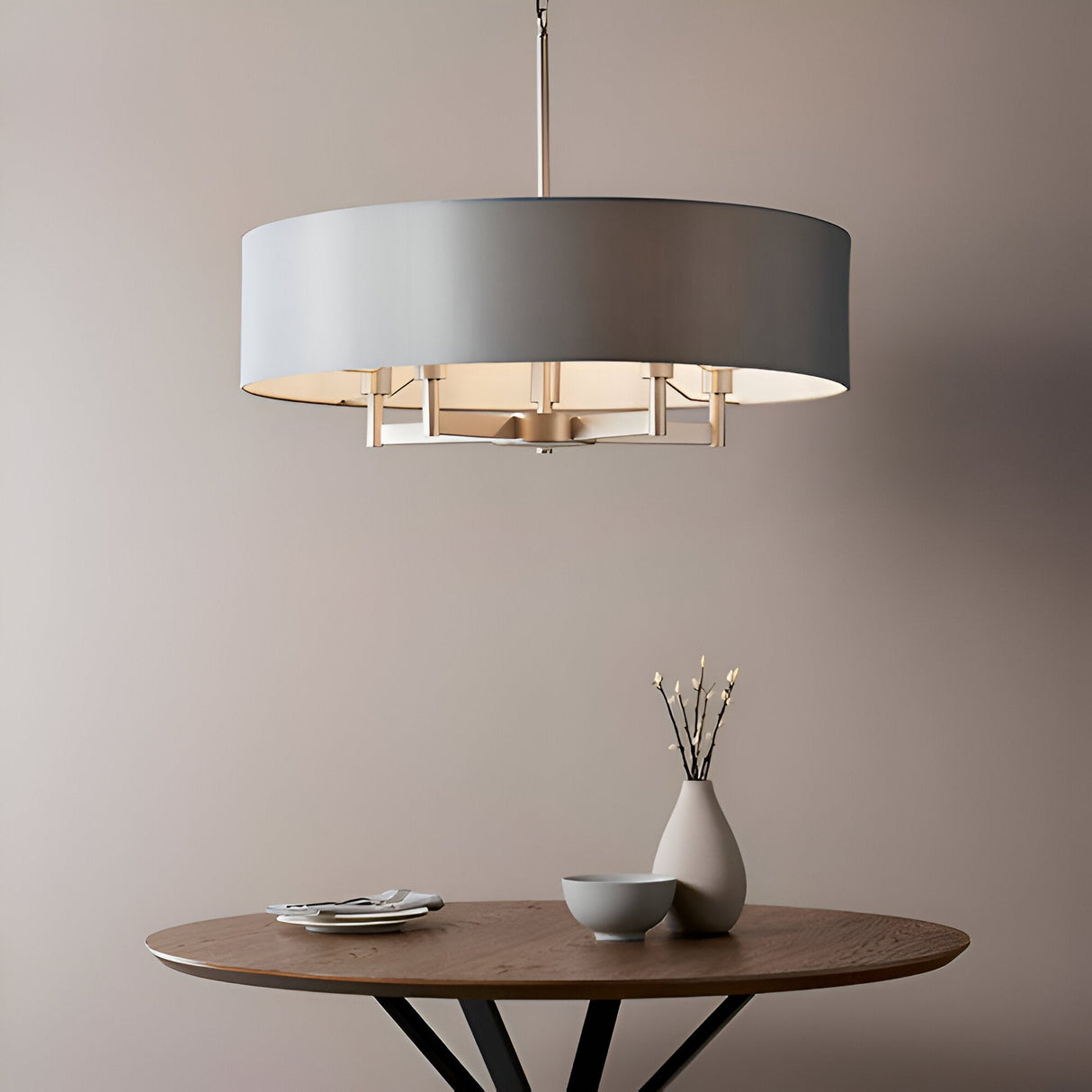 Endon Bramstead 5 light pendant with a wide grey fabric drum shade on a matt nickel frame, hanging above a round wooden table with a vase and bowl.
