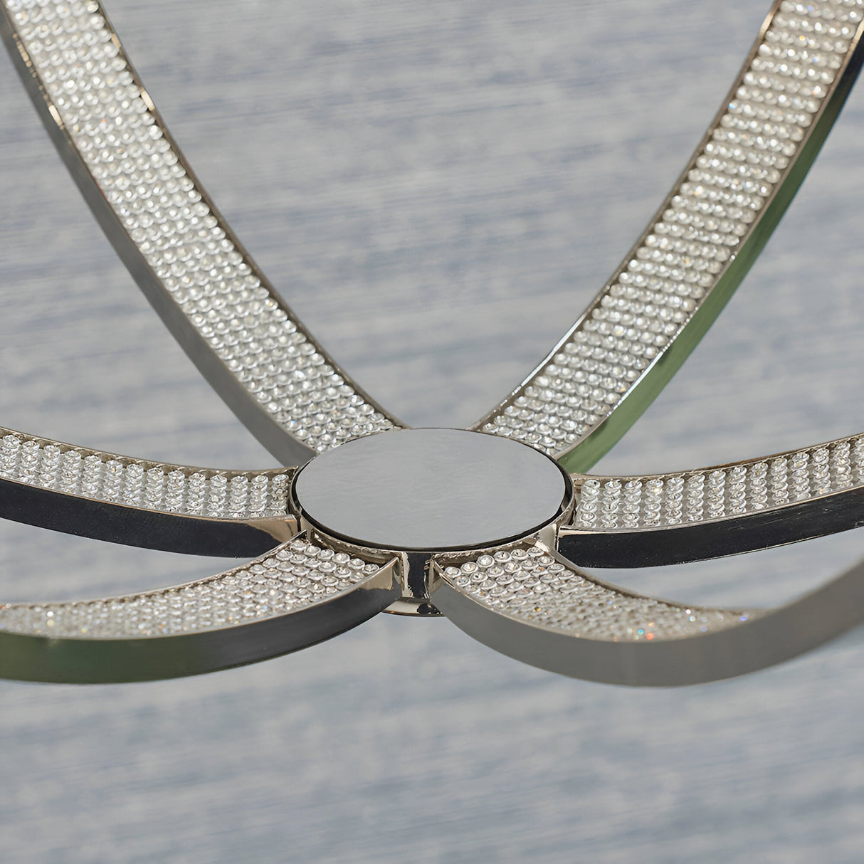 Close-up of the Cliffbury 6 Light Pendant in nickel, showing curved open metal arms encrusted with faceted crystal detail meeting at a round centre disc.