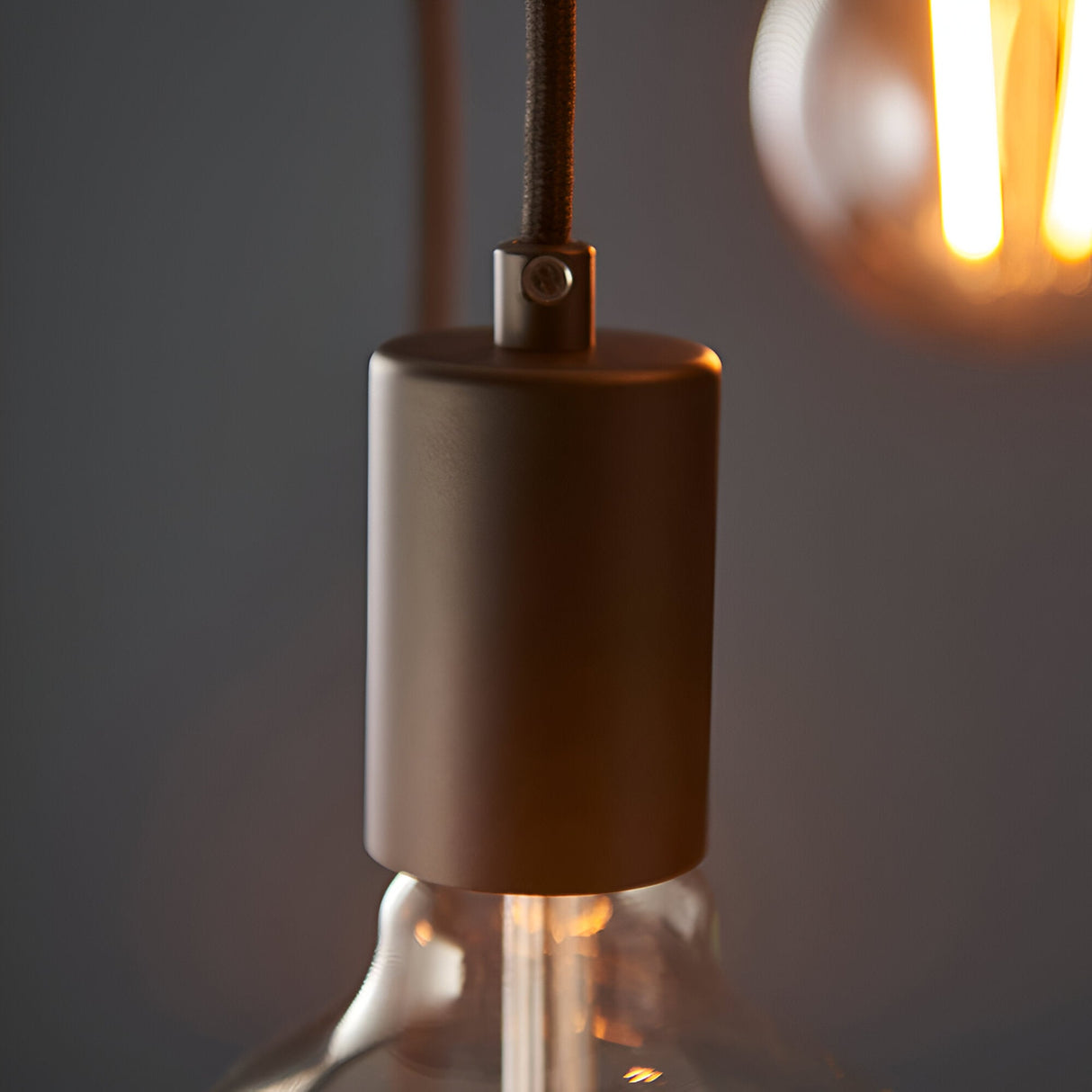 Marlowe 6 Light Pendant in matt black metal, close-up of E27 lamp holder with fabric flex cord and glass globe bulb, industrial style.