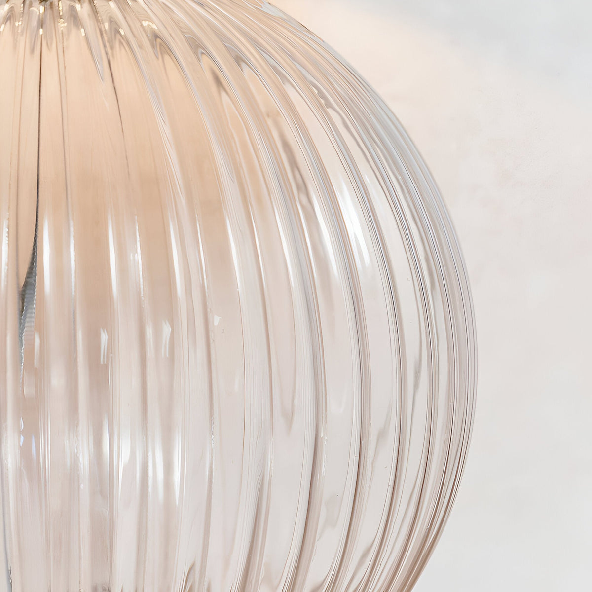 Close-up of the Endon Brockdale table lamp base showing clear ribbed glass with satin nickel detailing against a light neutral background.