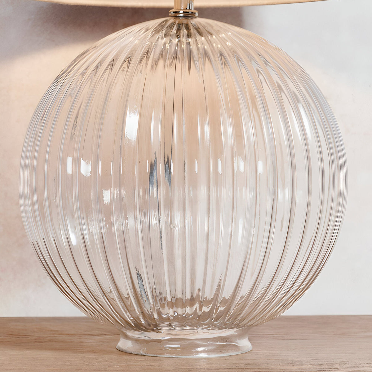 Endon Brockdale table lamp base with clear ribbed globe glass and satin nickel neck, shown on a wooden surface beneath a fabric shade.