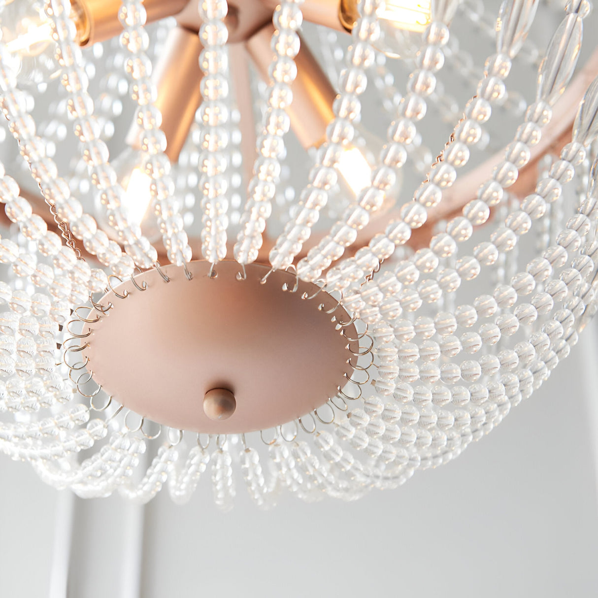 Close-up of the Bevdale 5 Light Pendant in gold, showing clear glass bead strands draped from the metal frame with visible bulbs and central mounting plate.