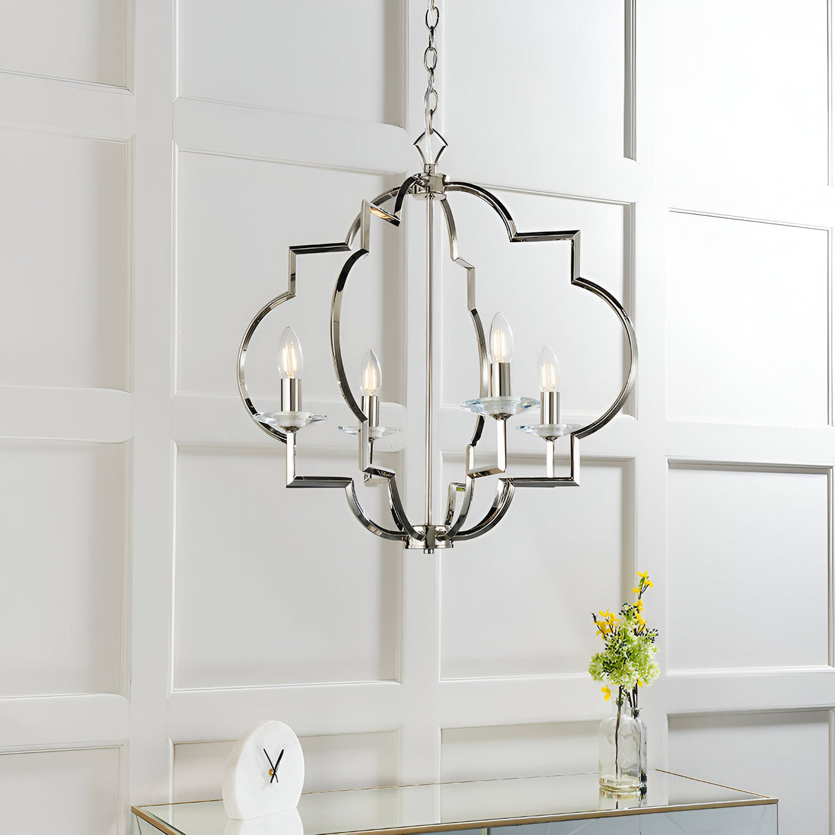 Bramfield 4 Light Pendant in polished nickel with quatrefoil frame and crystal bobeches, hanging from a chain in a panelled white room.