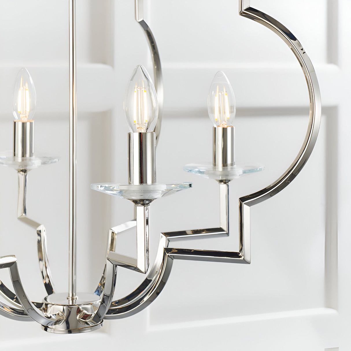 Close-up of the Bramfield 4-Light Pendant in polished nickel with candle bulbs, crystal glass bobeches, and angular metal arms.
