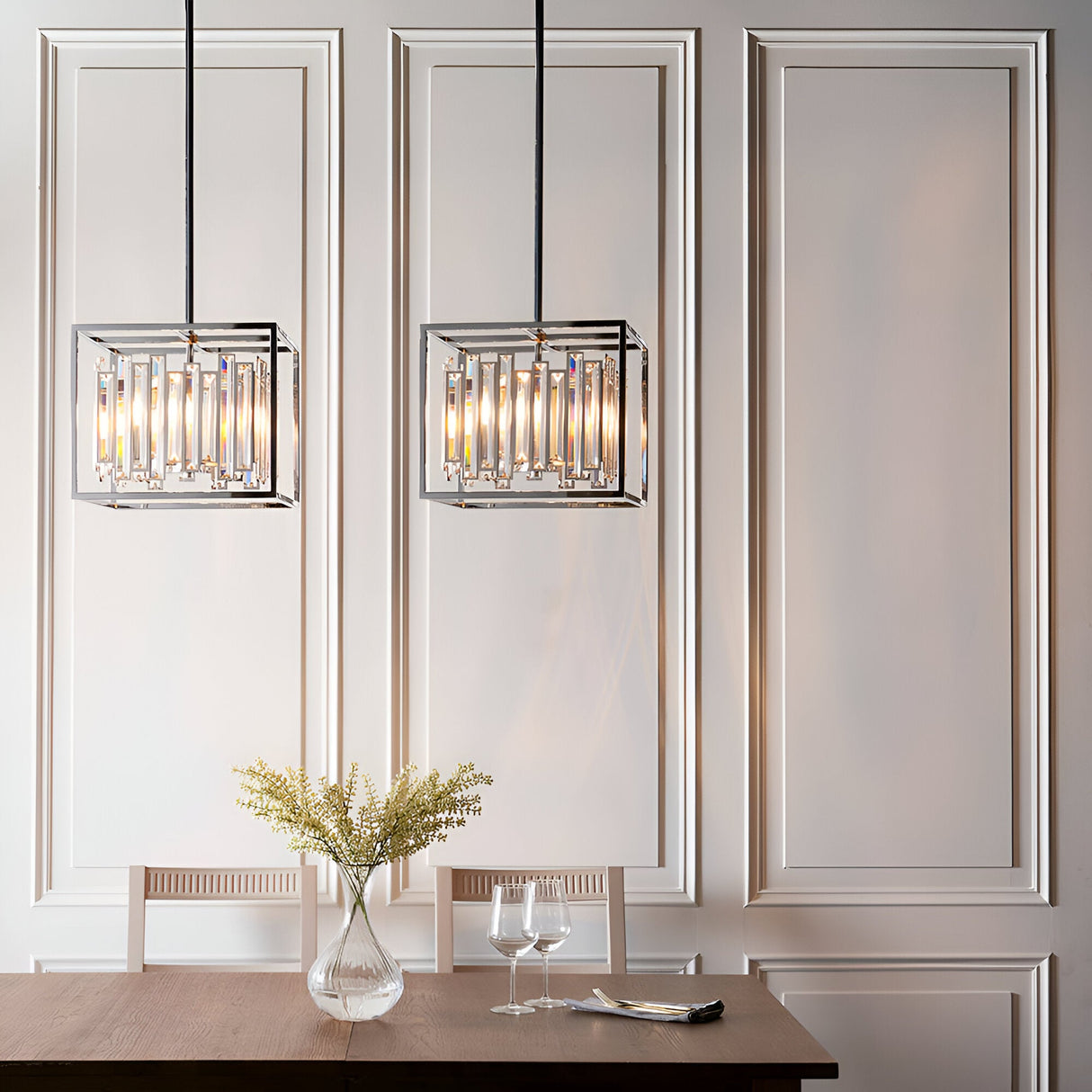 Pair of Endon Aldbourne 4 light pendants in polished chrome with bevelled glass crystals, hung above a dining table against panelled white walls.