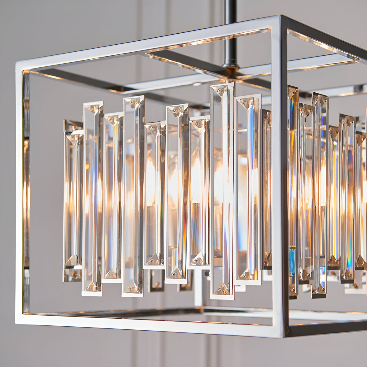 Endon Aldbourne 4 light pendant with square polished chrome frame and bevelled glass crystal drops, shown illuminated in close-up detail.
