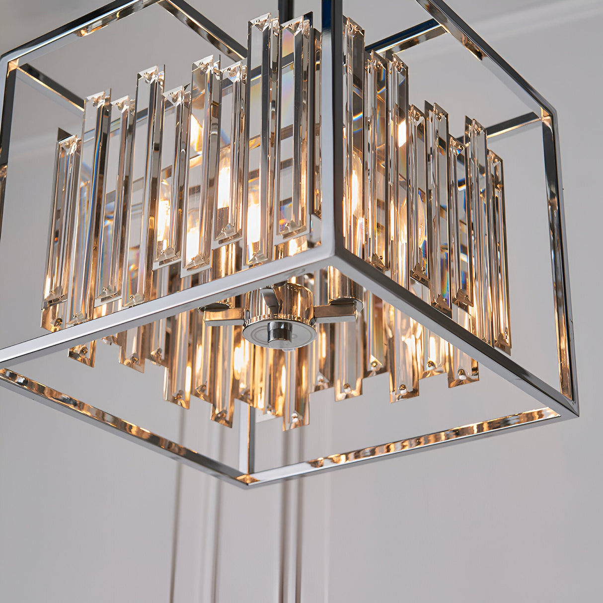 Endon Aldbourne 4 light square pendant in polished chrome with tiered bevelled glass crystals, shown illuminated from below against a pale ceiling.