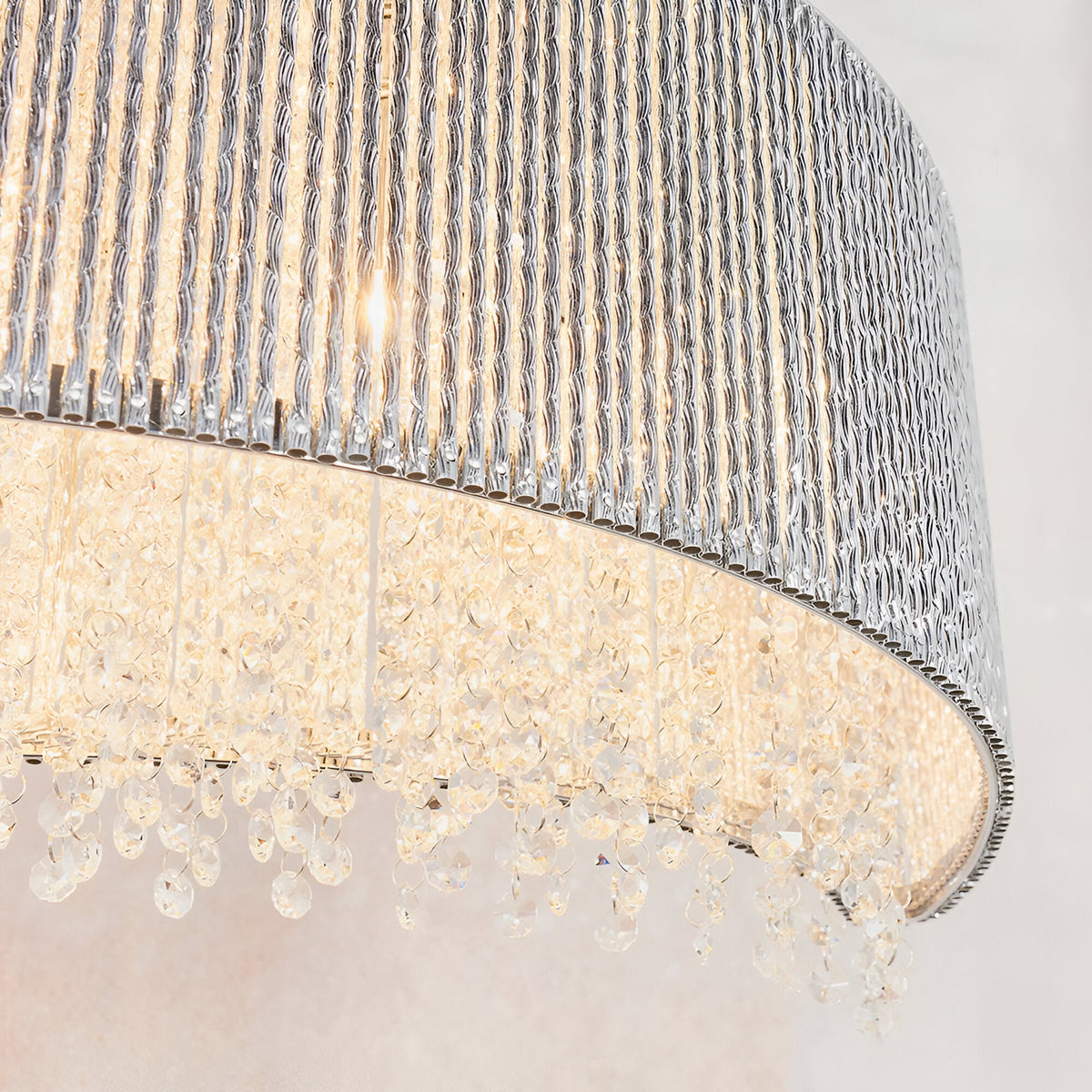 Close-up of Endon Isadora linear pendant showing twisted polished chrome rods and cascading clear K9 crystals lit by G9 lamps.