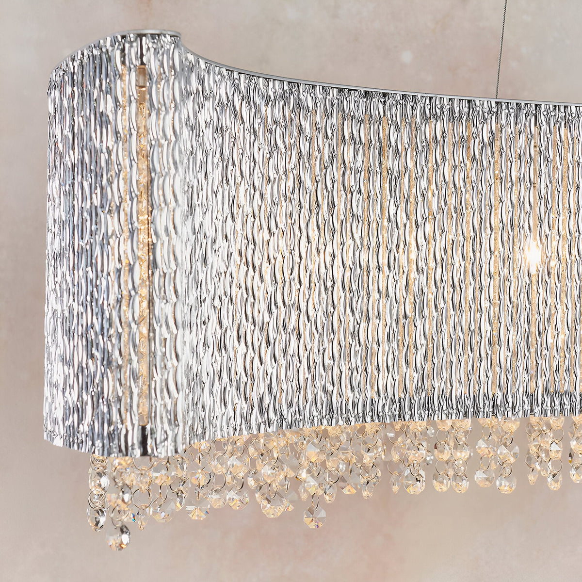 Endon Isadora linear pendant close-up showing twisted polished chrome rods forming a wave shade with clear crystal droplets suspended beneath.