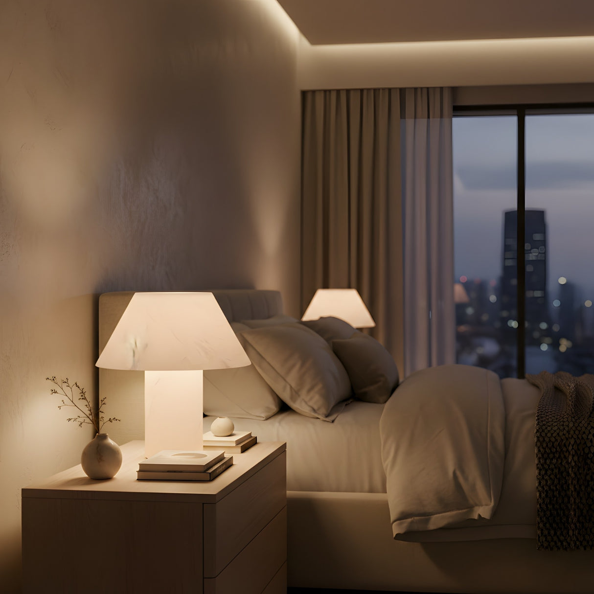 A cozy bedroom at dusk features the Lunessa LED Small Sculpted Mushroom Alabaster Table Lamp – Soft White on the nightstand with stacked books, a small vase, gray pillows on a neatly made bed, and large windows revealing the cityscape.