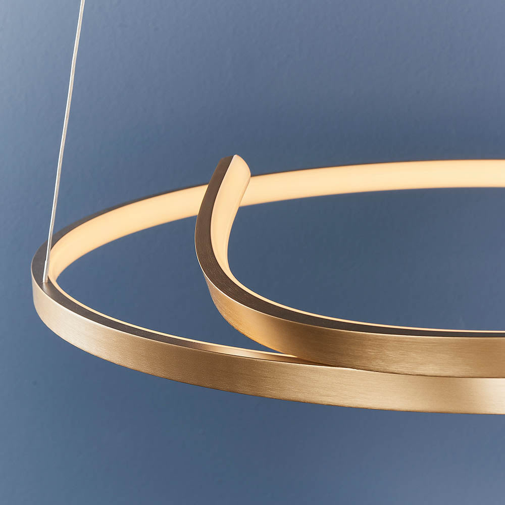 Close-up of the Endon Chartmont pendant light showing its slim looped ring form in matt brushed gold with a frosted diffuser, against a blue wall.