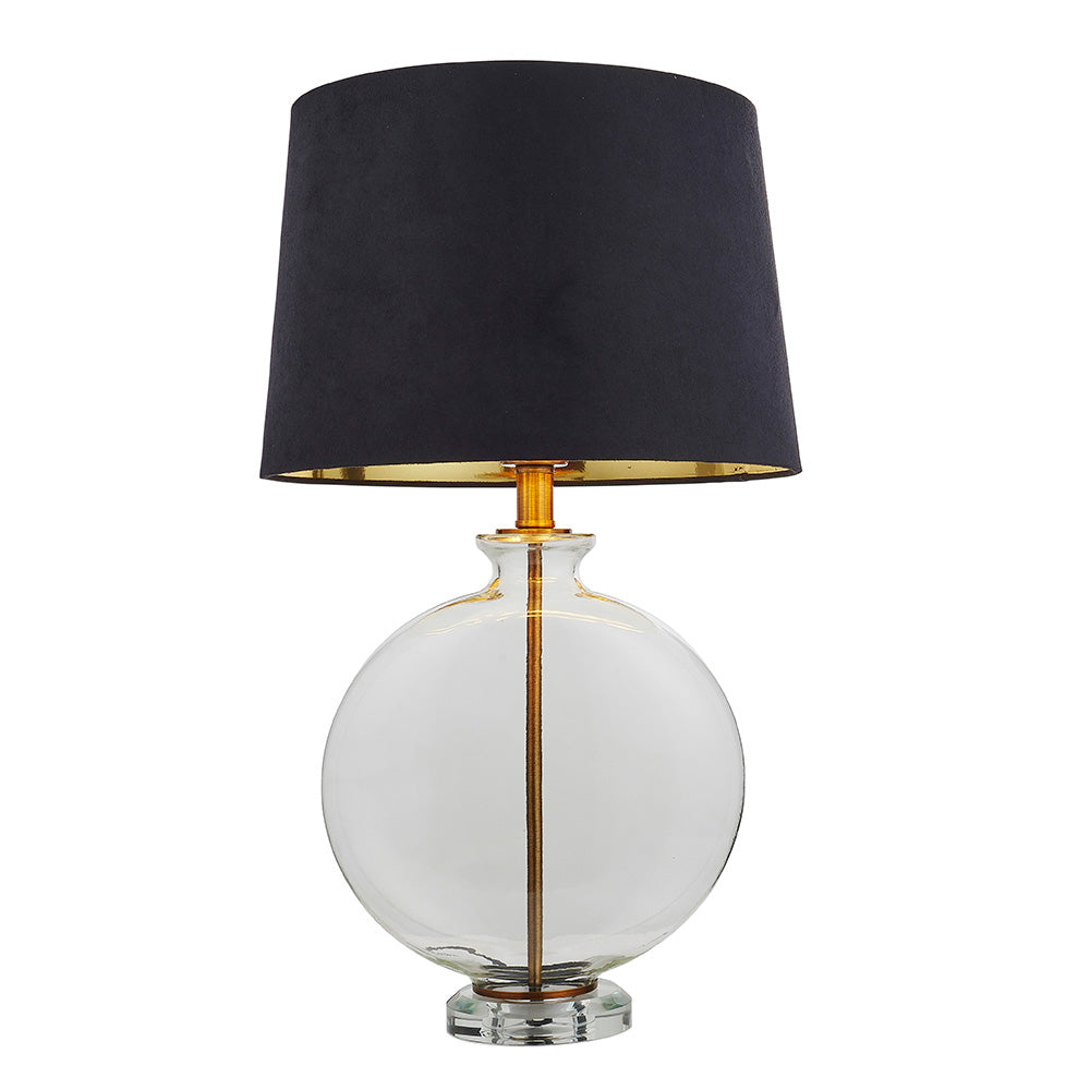 Endon Bramleigh table lamp with a clear glass ellipsoid base, antique brass stem and tapered black faux suede shade, on a white background.