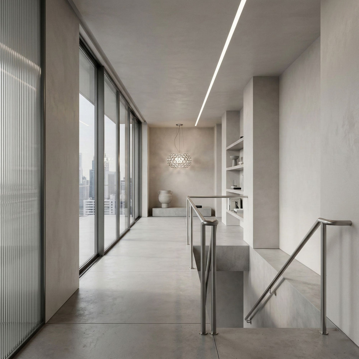 A modern hallway features concrete floors, large windows with a city skyline view, built-in shelves, a metal handrail, and the Briller LED Large Suspension Light - Clear hanging elegantly at the end near a white vase.