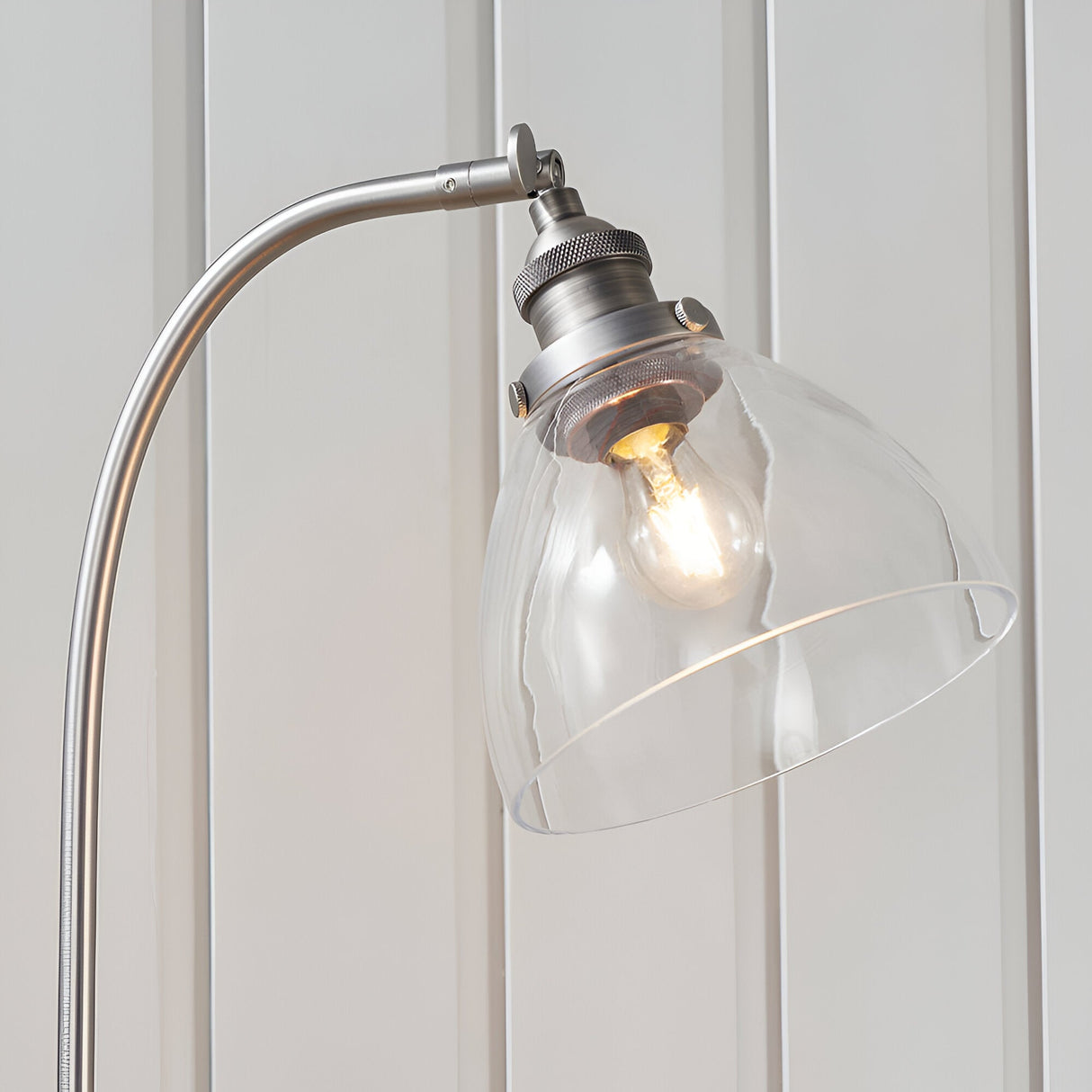 Close-up of the Endon Wentworth table lamp in silver, showing the curved arm, knurled adjustable knuckle, clear glass shade and exposed filament bulb.