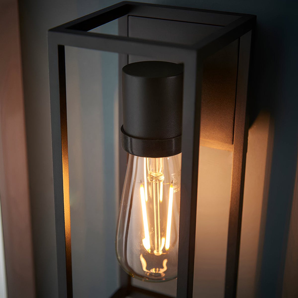 Brenford Outdoor Wall Light in black, open lantern-style aluminium frame with visible E27 filament bulb, IP44 rated for outdoor use.